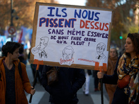 Two protesters hold a cardboard sign reading, 'They piss on us and they don't even try to persuade us it's raining.' Between 8,000 and 10,00...