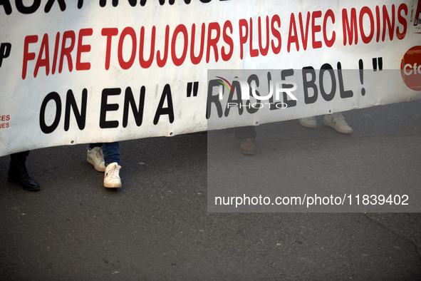 The banner reads 'Doing always more with always less, we're fed up'. Between 8,000 and 10,000 protesters march in Toulouse, France, on Decem...