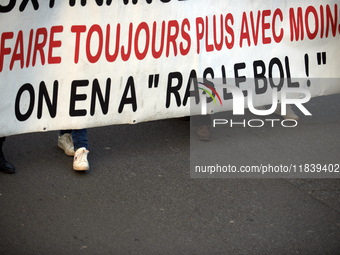 The banner reads 'Doing always more with always less, we're fed up'. Between 8,000 and 10,000 protesters march in Toulouse, France, on Decem...