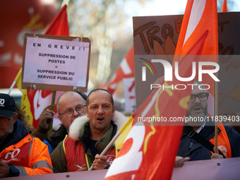 A placard reads 'On strike, jobs cut: public services removal'. Between 8,000 and 10,000 protesters march in Toulouse, France, on December 5...