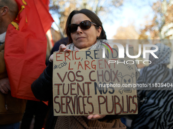 A woman holds a placard reading 'Give us back the money, your choices are killing our public services'. Between 8,000 and 10,000 protesters...