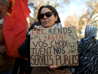 A woman holds a placard reading 'Give us back the money, your choices are killing our public services'. Between 8,000 and 10,000 protesters...