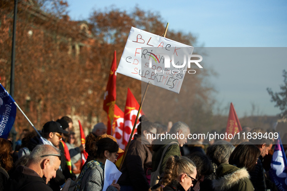 A placard reads 'Black Friday, 500 jobs cut'. Between 8,000 and 10,000 protesters march in Toulouse, France, on December 5, 2024, called by...