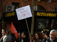 A woman holds a placard reading 'Social action sacrificed'. Between 8,000 and 10,000 protesters march in Toulouse, France, on December 5, 20...