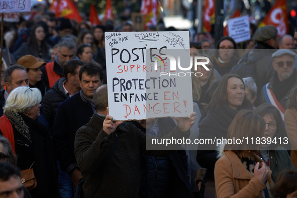 A protester holds a placard reading 'Jobs cut, child welfare service in danger'. Between 8,000 and 10,000 protesters march in Toulouse, Fran...