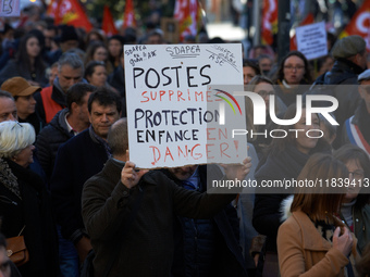 A protester holds a placard reading 'Jobs cut, child welfare service in danger'. Between 8,000 and 10,000 protesters march in Toulouse, Fran...