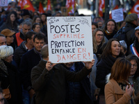 A protester holds a placard reading 'Jobs cut, child welfare service in danger'. Between 8,000 and 10,000 protesters march in Toulouse, Fran...