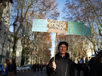 A woman holds a placard reading 'Don't let them divide us, Sarkozy, Le Pen, Bardella in jail, destitution of Macron'. Between 8,000 and 10,0...