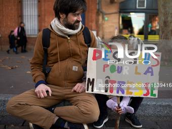 A young girl holds a placard reading 'money for my schoolteacher'. Between 8,000 and 10,000 protesters march in Toulouse, France, on Decembe...