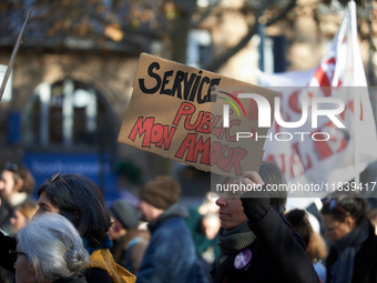 A protester holds a cardboard sign reading 'Public services, my love'. Between 8,000 and 10,000 protesters march in Toulouse, France, on Dec...