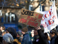 A protester holds a cardboard sign reading 'Public services, my love'. Between 8,000 and 10,000 protesters march in Toulouse, France, on Dec...