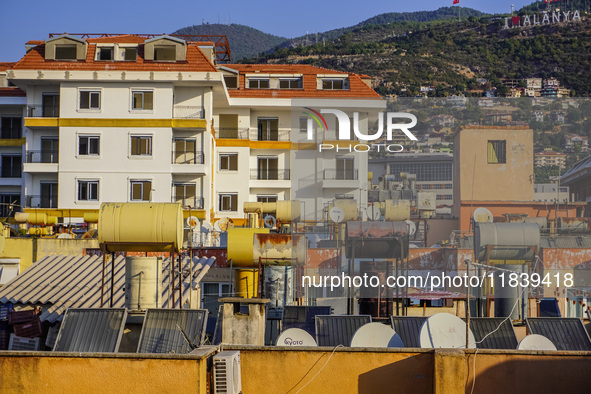 A general view of the dense city development with visible roofs full of solar installations for heating water is seen in Alanya, Antalya, Tu...