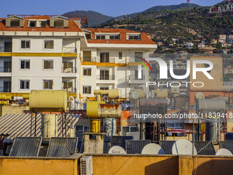 A general view of the dense city development with visible roofs full of solar installations for heating water is seen in Alanya, Antalya, Tu...