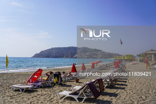 Tourists relax on beach loungers on the beach of the Mediterranean Sea in Alanya, Turkey, on November 3, 2024 