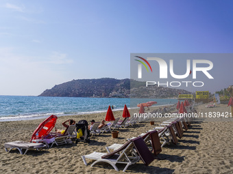 Tourists relax on beach loungers on the beach of the Mediterranean Sea in Alanya, Turkey, on November 3, 2024 (