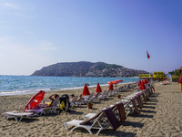 Tourists relax on beach loungers on the beach of the Mediterranean Sea in Alanya, Turkey, on November 3, 2024 (