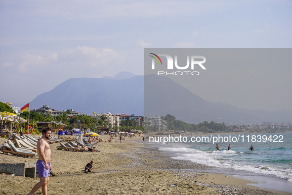 Tourists relax on beach loungers on the beach of the Mediterranean Sea in Alanya, Turkey, on November 3, 2024 