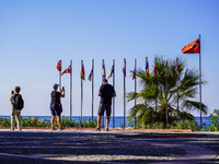 People take pictures of the Turkish flag in the wind on the Mediterranean Sea coast with their smartphones in Alanya, Turkey, on November 5,...