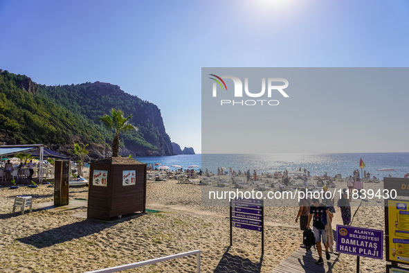 Tourists relax on Damlatas Beach of the Mediterranean Sea in Alanya, Turkey, on November 3, 2024 