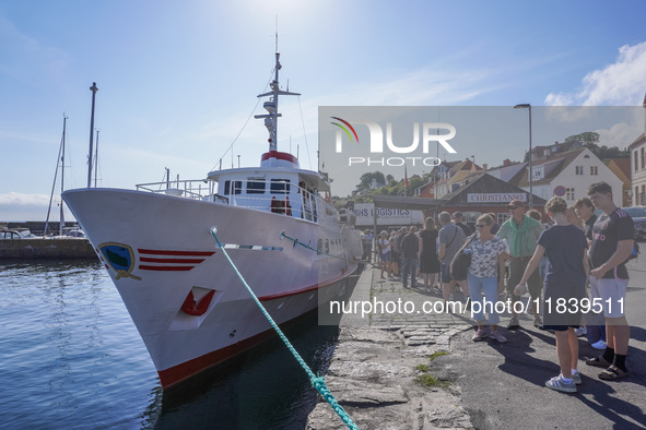 People wait in line for the ship connecting Bornholm Island and Christianso Island in Bornholm Island, Denmark, on August 6, 2024 