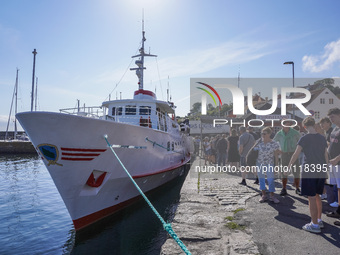 People wait in line for the ship connecting Bornholm Island and Christianso Island in Bornholm Island, Denmark, on August 6, 2024 (