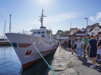 People wait in line for the ship connecting Bornholm Island and Christianso Island in Bornholm Island, Denmark, on August 6, 2024 (