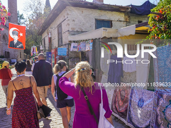 People visit a local market in Alanya, Turkey, on November 5, 2024. A portrait of Mustafa Kemal Ataturk hangs above a street. (