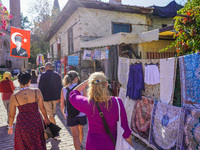 People visit a local market in Alanya, Turkey, on November 5, 2024. A portrait of Mustafa Kemal Ataturk hangs above a street. (