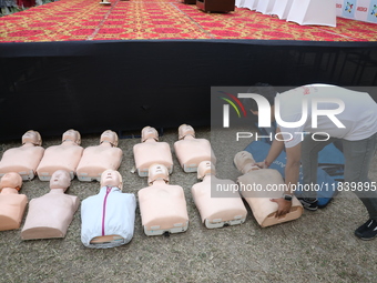 A medical official arranges mannequins before demonstrating lifesaving Cardiopulmonary Resuscitation (CPR) on a mannequin with breathing pro...