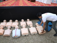 A medical official arranges mannequins before demonstrating lifesaving Cardiopulmonary Resuscitation (CPR) on a mannequin with breathing pro...