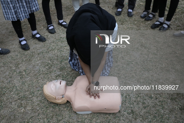 A medical official demonstrates lifesaving Cardiopulmonary Resuscitation (CPR) on a mannequin with breathing problems during a CPR training...