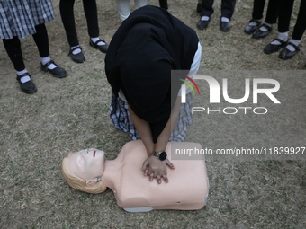 A medical official demonstrates lifesaving Cardiopulmonary Resuscitation (CPR) on a mannequin with breathing problems during a CPR training...