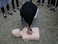 A medical official demonstrates lifesaving Cardiopulmonary Resuscitation (CPR) on a mannequin with breathing problems during a CPR training...