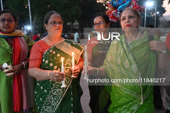 Members of a social organization hold a candlelight vigil in memory of relatives lost in the Liberation War of 1971 and those killed in the...