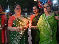 Members of a social organization hold a candlelight vigil in memory of relatives lost in the Liberation War of 1971 and those killed in the...