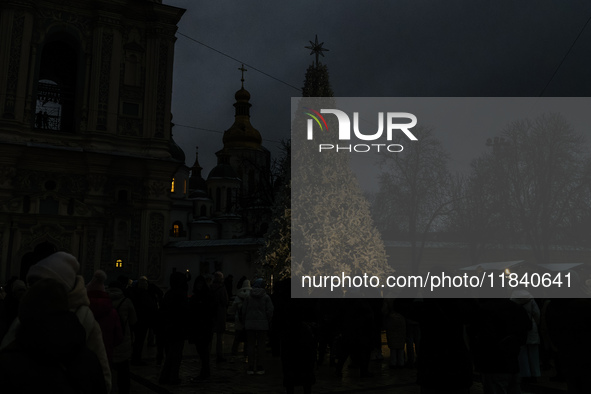 People walk around Ukraine's main Christmas tree before its lights are switched on amid Russia's attack on Ukraine in Sophia Square in Kyiv,...