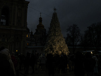 People walk around Ukraine's main Christmas tree before its lights are switched on amid Russia's attack on Ukraine in Sophia Square in Kyiv,...