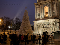 People walk around Ukraine's main Christmas tree after its lights are switched on amid Russia's attack on Ukraine in Sophia Square in Kyiv,...