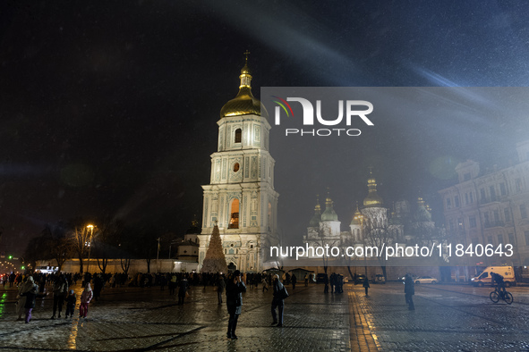 People walk around Ukraine's main Christmas tree before its lights are switched on amid Russia's attack on Ukraine in Sophia Square in Kyiv,...