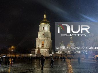 People walk around Ukraine's main Christmas tree before its lights are switched on amid Russia's attack on Ukraine in Sophia Square in Kyiv,...