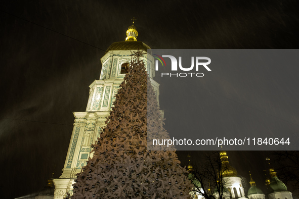 People walk around Ukraine's main Christmas tree before its lights are switched on amid Russia's attack on Ukraine in Sophia Square in Kyiv,...