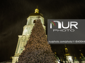 People walk around Ukraine's main Christmas tree before its lights are switched on amid Russia's attack on Ukraine in Sophia Square in Kyiv,...