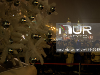 People walk around Ukraine's main Christmas tree before its lights are switched on amid Russia's attack on Ukraine in Sophia Square in Kyiv,...