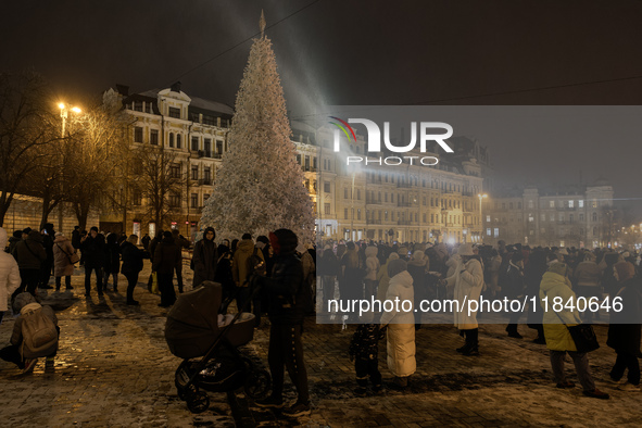 People walk around Ukraine's main Christmas tree before its lights are switched on amid Russia's attack on Ukraine in Sophia Square in Kyiv,...