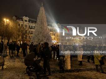 People walk around Ukraine's main Christmas tree before its lights are switched on amid Russia's attack on Ukraine in Sophia Square in Kyiv,...