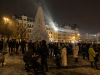 People walk around Ukraine's main Christmas tree before its lights are switched on amid Russia's attack on Ukraine in Sophia Square in Kyiv,...