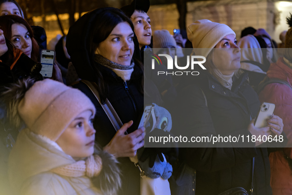 People walk around Ukraine's main Christmas tree after its lights are switched on amid Russia's attack on Ukraine in Sophia Square in Kyiv,...