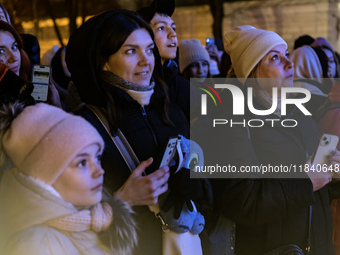 People walk around Ukraine's main Christmas tree after its lights are switched on amid Russia's attack on Ukraine in Sophia Square in Kyiv,...