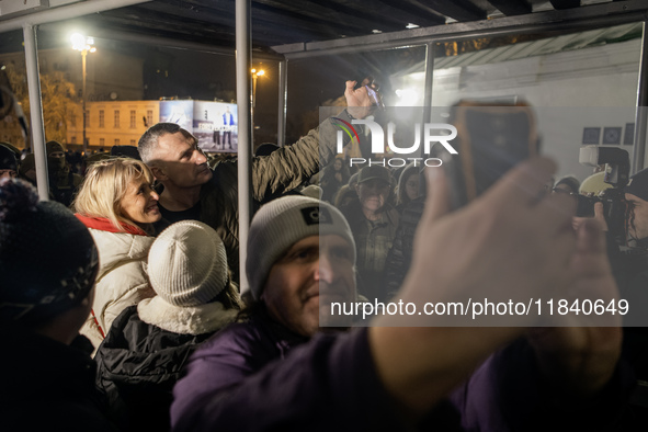 People take pictures with Kyiv Mayor Vitali Klitschko near Ukraine's main Christmas tree after its lights are switched on, amid Russia's att...