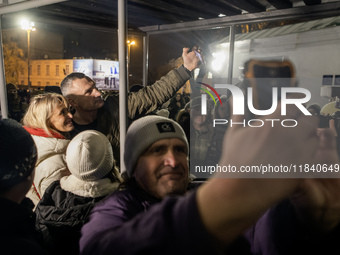 People take pictures with Kyiv Mayor Vitali Klitschko near Ukraine's main Christmas tree after its lights are switched on, amid Russia's att...